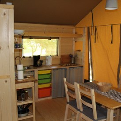 Interior view of Camping Ammertal - Lodges Beieren glamping accommodation with wooden furniture and kitchen area.