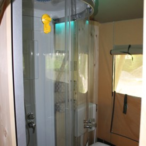 Intérieur d’une salle de bain glamping au Camping Ammertal - Lodges Beieren équipée d’une douche ronde.