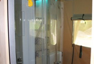 Modernes Bad mit runder Dusche und Fenster in einer Glamping-Lodge bei Camping Ammertal - Lodges Beieren.