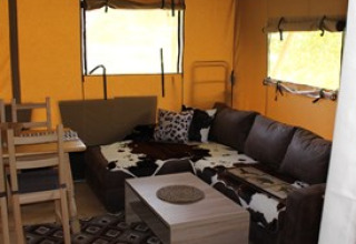 Vue intérieure d'une tente glamping confortable avec canapé et table au Camping Ammertal - Lodges Beieren.