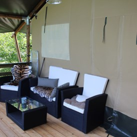 Comfortable glamping seating area with black and white chairs at Camping Ammertal - Lodges Beieren.