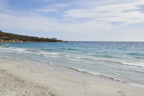 Zandstrand en blauwe zee bij Lavita Camp Cagliari - Glampingtenten Sardinië aan de kust van Italië.