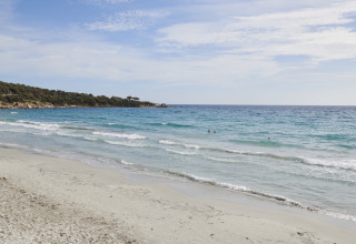 Zandstrand en blauwe zee bij Lavita Camp Cagliari - Glampingtenten Sardinië, perfect voor glamping.