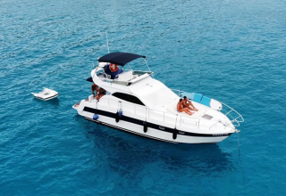 Een luxe jacht met mensen aan boord drijft op helderblauw water bij Lavita Camp Cagliari op Sardinië.