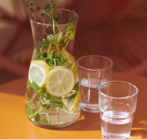 Carafe with lemon and herbs water, served with two glasses at Lavita Camp Cagliari glamping in Sardinia.