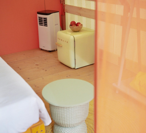 Interno di tenda glamping Lavita Camp Cagliari con mini frigo retrò e tavolino in Sardegna.