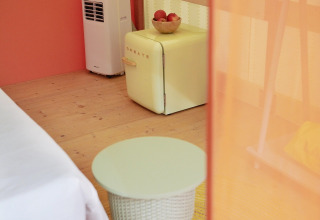 Interno di tenda glamping Lavita Camp Cagliari con mini frigo retrò e tavolino in Sardegna.