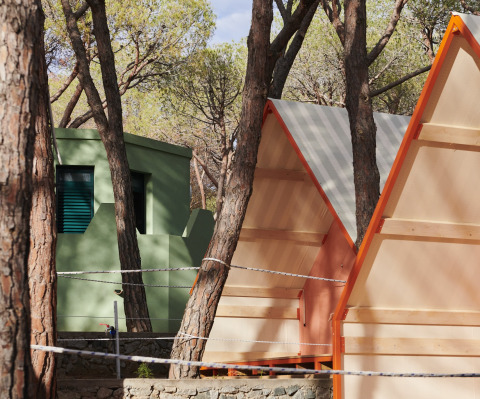 Alojamiento glamping en Lavita Camp Cagliari, Cerdeña, con tiendas y cabañas verdes entre los árboles.