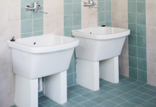 Twee witte lavabo’s in de badkamer bij Lavita Camp Cagliari - Glampingtenten Sardinië glampingverblijf.