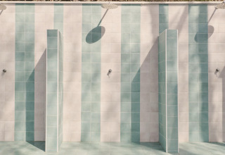 Outdoor shower area with blue and white tiles at Lavita Camp Cagliari - Glampingtenten Sardinia.