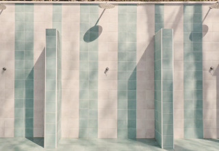 Area doccia esterna con piastrelle blu e bianche a Lavita Camp Cagliari - Glampingtenten Sardegna.