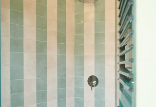 Douche moderne avec carrelage vert et beige au Lavita Camp Cagliari, tentes glamping en Sardaigne.