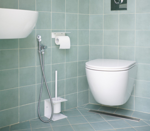 Bagno moderno al Lavita Camp Cagliari con wc sospeso, doccetta igienica e scopino.