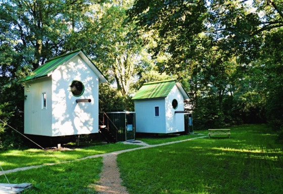 Deux cabanes de glamping uniques aux toits verts à De Vreemde Vogel, Zuid-Holland, Pays-Bas, en pleine nature.