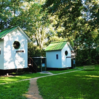 Due originali cabine glamping con tetti verdi a De Vreemde Vogel in Zuid-Holland, Paesi Bassi, immerse nella natura.