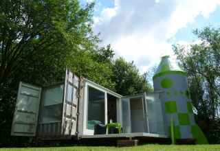 Außergewöhnliche Glamping-Unterkunft in Südholland mit Containerhaus und Raketenmotiv im Grünen.