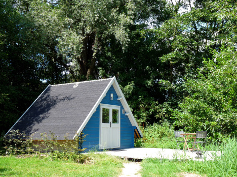 Petite cabane de glamping bleue en forme de A avec terrasse, entourée de verdure chez De Vreemde Vogel, Sud-Holland.