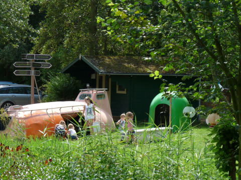 Børn leger i unikke glampingindkvarteringer hos De Vreemde Vogel i grønne omgivelser i Sydholland.
