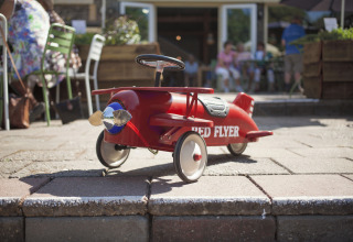 Aereo a pedali rosso 'Red Flyer' all’aperto al glamping unico De Vreemde Vogel in Zuid-Holland.