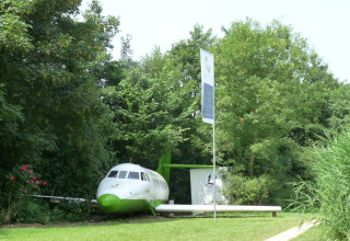 Hébergement glamping insolite dans un avion chez De Vreemde Vogel, entouré de verdure à Zuid-Holland.