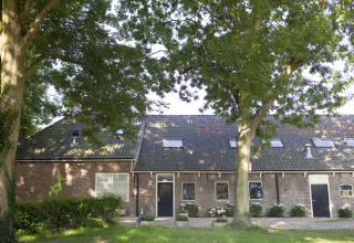 Udvendigt billede af De Vreemde Vogel, unik glamping indkvartering i Zuid-Holland omgivet af træer.