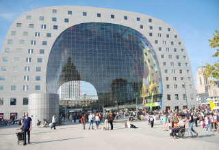 Il moderno Markthal di Rotterdam, Paesi Bassi, con vetrata ad arco e molte persone all'ingresso.