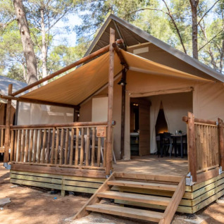 Glamping accommodation with safari tent cabin in the woods at Camping & Resort La Torre del Sol, Costa Dorada.