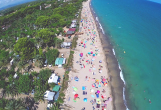 Luchtfoto van Camping & Resort La Torre del Sol - Safaritenten Costa Dorada met druk strand en gekleurde parasols.