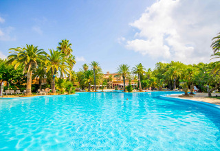 Großer Pool mit Palmen im Camping & Resort La Torre del Sol, Safarizelte an der Costa Dorada, Spanien.