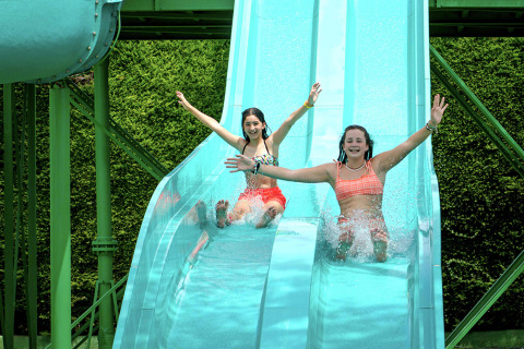 Due ragazze felici si divertono sullo scivolo d'acqua al Camping & Resort La Torre del Sol, Costa Dorada.