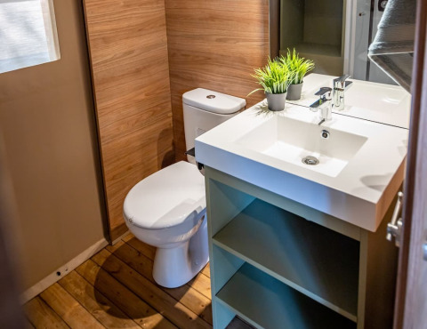 Bagno moderno in tenda safari al Camping & Resort La Torre del Sol, Costa Dorada, con dettagli in legno.