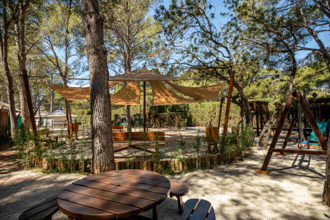 Espace extérieur ombragé avec tables et aire de jeux au Camping & Resort La Torre del Sol - Safaritenten Costa Dorada