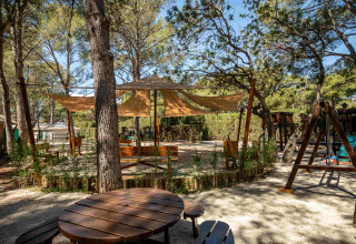 Espace extérieur ombragé avec tables et aire de jeux au Camping & Resort La Torre del Sol - Safaritenten Costa Dorada