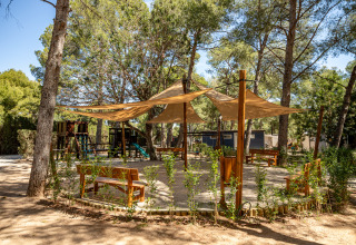 Spielplatz mit Sitzbänken und Sonnensegel im Camping & Resort La Torre del Sol, Costa Dorada.