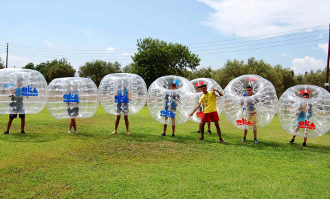 Kinder genießen Bubble Football am Camping & Resort La Torre del Sol, Costa Dorada, an einem sonnigen Tag.