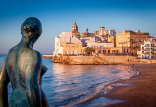 Strand- und Stadtblick in der Nähe des Camping & Resort La Torre del Sol - Safaritenten Costa Dorada bei Sonnenuntergang.