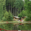 Glamping accommodation with safari tents by a pond, surrounded by forest at Safritop am Mühlenteich.