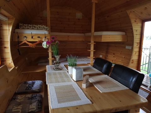Alojamiento de glamping acogedor en Kampeerbos de Simonshoek con interior de madera, mesa y literas.