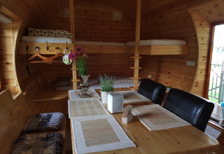 Knusse glampingaccommodatie bij Kampeerbos de Simonshoek met houten interieur, eettafel en stapelbedden.