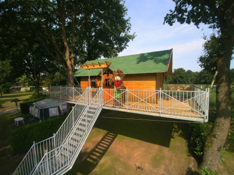 Alojamiento glamping tipo casa en el árbol en Kampeerbos de Simonshoek con terraza y escalera amplia.