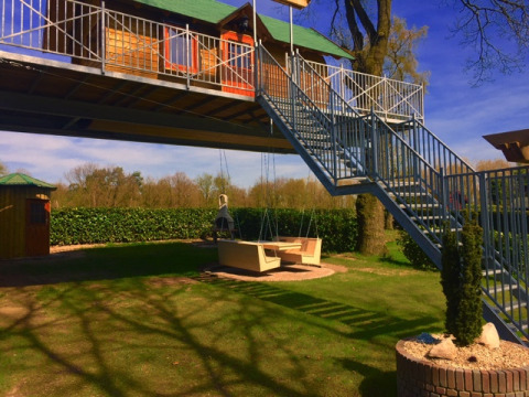Boomhut glamping met metalen trap en schommelbank bij Kampeerbos de Simonshoek te Nederland.