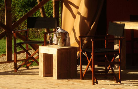 Zona de estar exterior en Kimaro Farmhouse Safaritenten Bourgogne con sillas, mesa y bebidas.