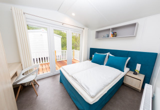 Modernes Glamping-Zimmer im Camping en Vakantiepark Teichmann, Hessen, mit Doppelbett und Terrasse.