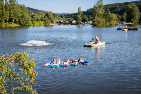 Mensen genieten van waterpret bij Camping en Vakantiepark Teichmann - Glamping Hessen, tussen groene heuvels.