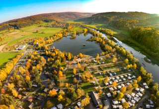 Vue aérienne de Camping en Vakantiepark Teichmann - Glamping Hessen avec lac, arbres d'automne et caravanes.
