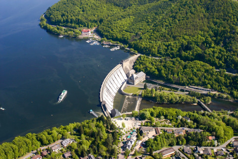 Luchtfoto van Camping en Vakantiepark Teichmann - Glamping Hessen aan een meer met dam en bos.