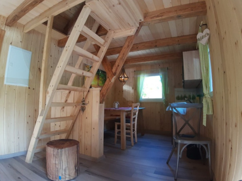 Gemütliche Holzhütte mit Esstisch, Leiter zu einer Schlafempore und rustikaler Einrichtung, Gallushof.