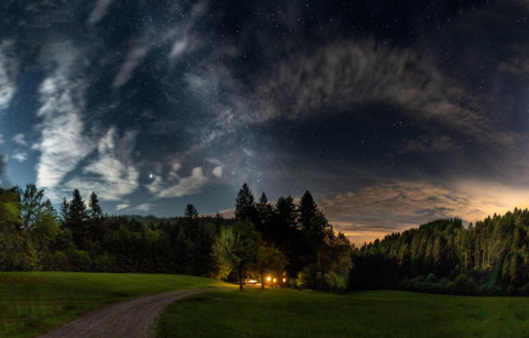 Cielo stellato sul glamping Gallushof nella campagna del Baden-Württemberg, con baita illuminata nel bosco.