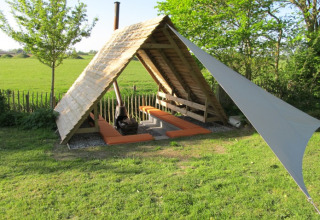 Duurzaam glampingverblijf bij It Dreamlân - Ecolodges Friesland, houten lodge en uitzicht op groene velden.