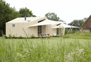 Ecolodges bei It Dreamlân in Friesland, umgeben von grüner Wiese, perfekter Ort für Glamping und Camping.